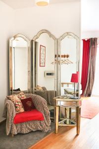 a living room with a couch and a table and mirrors at A La Villa Boucicaut in Chalon-sur-Saône