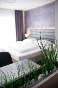 um quarto com duas camas e uma mesa com plantas em Hotel Rieth em Böblingen