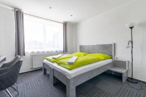 een slaapkamer met een bed met gele kussens en een raam bij Garni Hotel 31 in Spišská Nová Ves