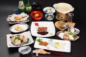 een tafel met veel borden eten erop bij Ryoso Kawaguchi in Miyajima