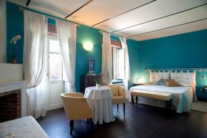 een slaapkamer met blauwe muren en een bed en een tafel bij Hotel Cascina Di Corte in Venaria Reale