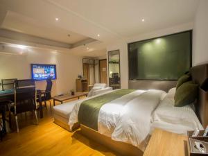 a bedroom with a bed and a flat screen tv at GreenTree Inn Haikou Haixiu Middle Road in Haikou