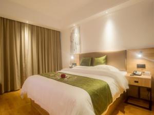 a hotel room with a large bed and a desk at GreenTree Inn Haikou Haixiu Middle Road in Haikou