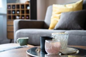 a table with a tray with two cups and a couch at Appartement-Leuchtturmblick in Hörnum