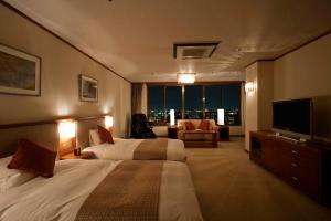 a hotel room with a bed and a television at Dogo Prince Hotel in Matsuyama