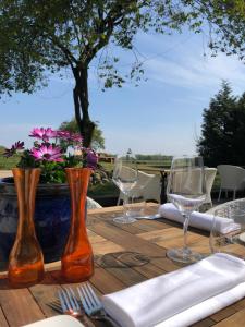 - une table en bois avec des verres à vin et des fleurs dans l'établissement Villa BlauwHemel Diever, à Diever