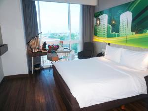 A bed or beds in a room at The Southern Hotel Surabaya Formerly Ibis Styles Surabaya Jemursari