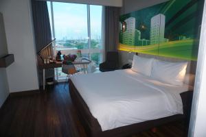 A bed or beds in a room at The Southern Hotel Surabaya Formerly Ibis Styles Surabaya Jemursari