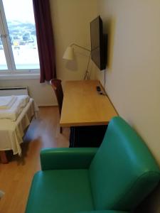 um quarto com uma secretária, uma cadeira e uma cama em Kirkenes Hotell em Kirkenes