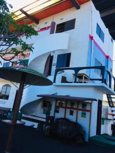 a boat with an umbrella in front of a building at Posada del Caminante in Puerto Villamil