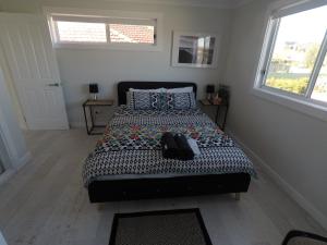 um quarto com uma cama com um edredão estampado em Lautan Cronulla Beach em Cronulla