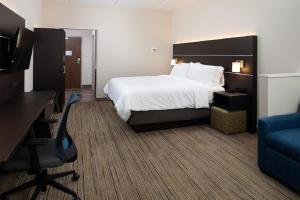 ein Hotelzimmer mit einem Bett, einem Schreibtisch und einem Stuhl in der Unterkunft Holiday Inn Express & Suites - Romeoville - Joliet North, an IHG Hotel in Romeoville