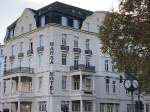 un bâtiment blanc avec une horloge devant lui dans l'établissement Star-Apart Hansa Hotel, à Wiesbaden