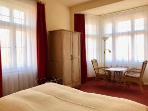 - une chambre avec un lit, une table et des chaises dans l'établissement Pension Villa Gisela, à Weimar