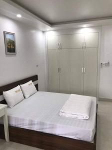 um quarto com uma cama grande e armários brancos em Cosy Star Apartment and Motel em Hai Phong