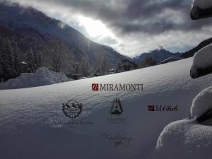 einen schneebedeckten Hang mit einem Berg im Hintergrund in der Unterkunft Le Miramonti Hotel Restaurant & Wellness in La Thuile