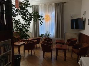 a room with chairs and tables and a window at Pribina Penzión in Nitra