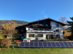 ein Haus mit Sonnenkollektoren davor in der Unterkunft Appartements Klausner in Altenmarkt im Pongau