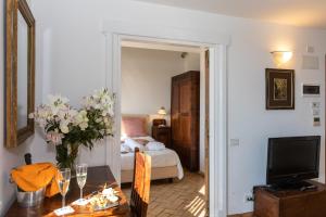 a room with a bed and a table with a vase of flowers at Residenza d'Epoca Pietra Di Ponente in Ciampino