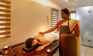 コーチにあるLhasa Ayurveda and Wellness Resort - A BluSalzz Collection, Kochi, Keralaの鏡に髪を整えている女