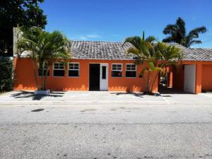 een oranje huis met palmbomen ervoor bij Villa Solarium Pousada in Cabo Frio