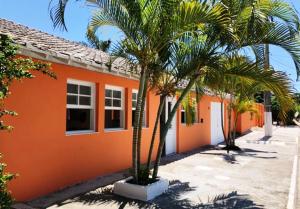 een oranje huis met palmbomen ervoor bij Villa Solarium Pousada in Cabo Frio