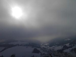 Chata Holica PIENINY في Lesnica: اطلاله على جبل ثلجي مع الشمس في الغيوم