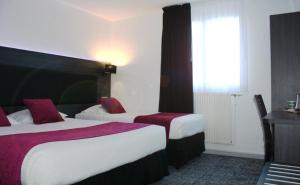 A bed or beds in a room at The Originals City Hôtel, Aéroport Beauvais