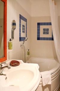 a bathroom with a white tub and a sink at A La Villa Boucicaut in Chalon-sur-Saône