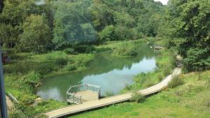 un puente sobre un río en un campo en Le Presbytère, en Differdange