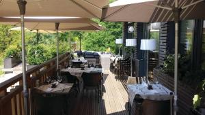 un restaurante con mesas y sombrillas en una terraza en Le Presbytère, en Differdange