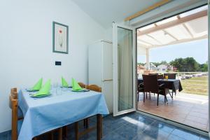 een eetkamer met een tafel en een patio bij Apartments Villa Brioni II in Fažana