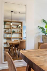 una sala da pranzo con tavolo, sedie e specchio di Apartments Ridderspoor a Bruges