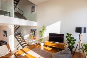 ein Wohnzimmer mit einer Treppe und einem TV in der Unterkunft River house in Porto