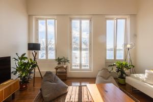 ein Wohnzimmer mit einem Sofa, einem Tisch und Fenstern in der Unterkunft River house in Porto