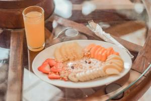 une assiette de fruits et légumes sur une table avec une boisson dans l'établissement Eco Suites Uxlabil Guatemala, à Guatemala