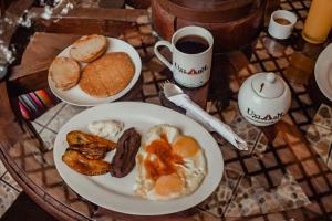 - une table avec une assiette de petit-déjeuner et une tasse de café dans l'établissement Eco Suites Uxlabil Guatemala, à Guatemala