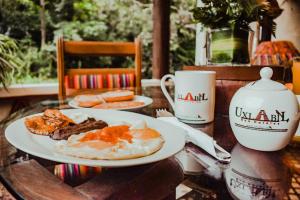 - une table avec deux assiettes de petit-déjeuner et une tasse dans l'établissement Eco Suites Uxlabil Guatemala, à Guatemala