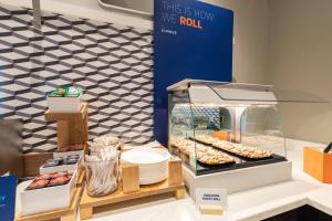 une vitrine avec des beignets et autres pâtisseries dans l'établissement Holiday Inn Express & Suites Woodside LaGuardia Airport, à Queens