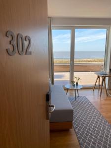 Zimmer mit einer Tür und Meerblick in der Unterkunft Hotel Strandhus in Cuxhaven