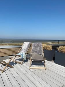 2 Liegestühle und ein Bett auf dem Dach in der Unterkunft Hotel Strandhus in Cuxhaven