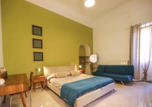 een slaapkamer met een bed en een blauwe bank bij Retrò B&B in Pisa