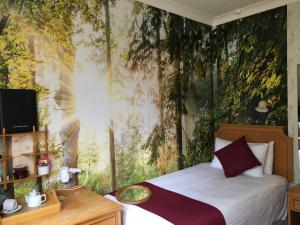 una camera da letto con un letto murale su un albero di The Nyton Guesthouse a Ely