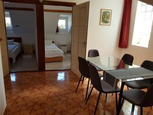 une salle à manger avec une table et des chaises ainsi qu'une chambre dans l'établissement Böne Vendégház és Borozó, à Tokaj