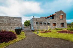 ein Steinhaus mit Garten davor in der Unterkunft Viveda Wellness Resort in Nashik