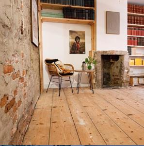 een kamer met een stoel, een tafel en een open haard bij Bookstor Hotel in Den Haag