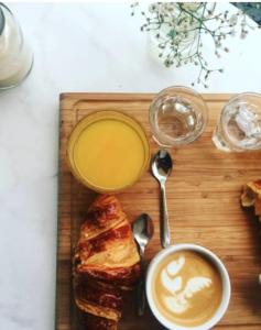 een houten snijplank met een bord eten en een kopje koffie bij Bookstor Hotel in Den Haag