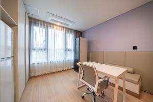 an office with a table and a chair in a room at SureStay Plus Hotel by Best Western Asan in Asan