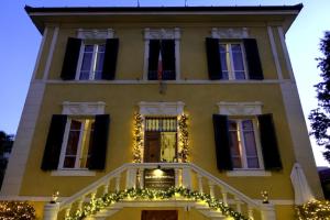 een geel huis met kerstverlichting ervoor bij Villa San Donato B&B in Lucca