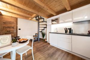 een keuken met witte kasten en een tafel en stoelen bij Aosta Centre Apartments - Martinet 17 in Aosta